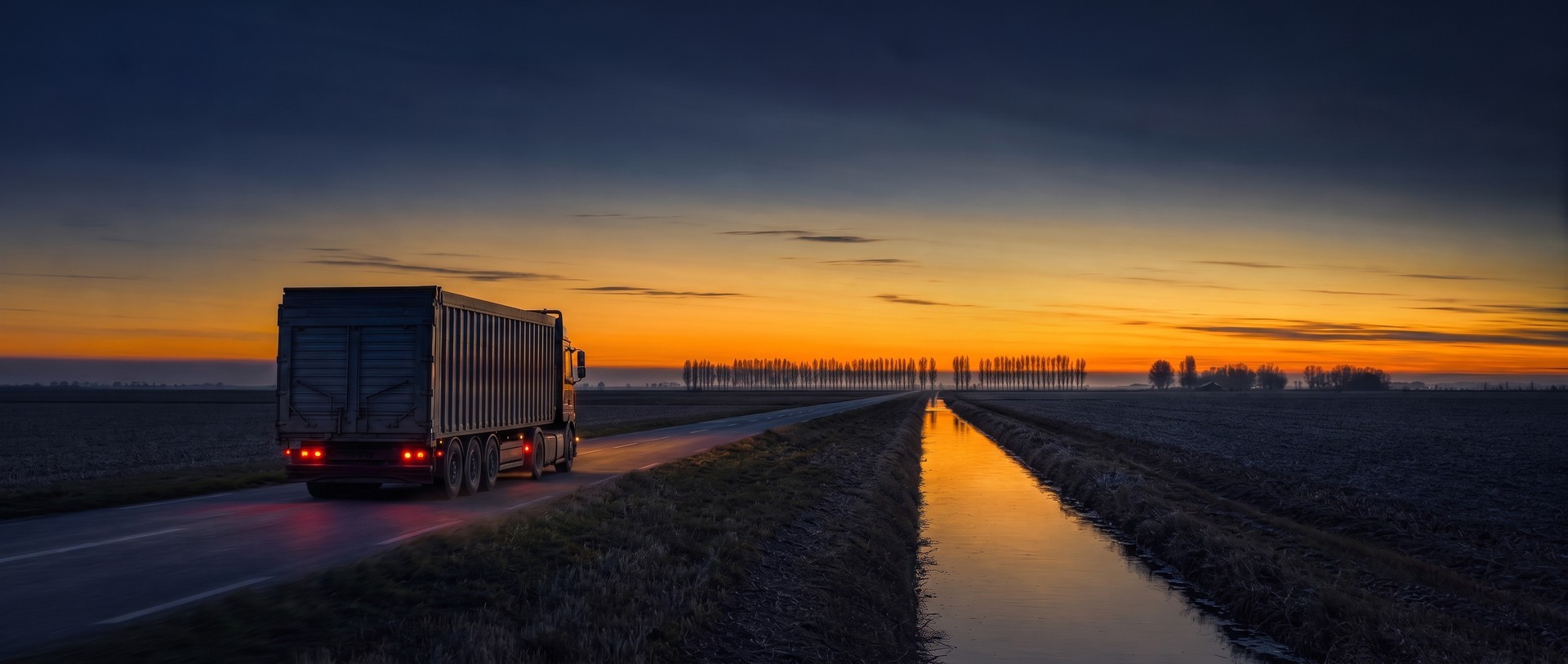 Transport zboża drogą wśród pól Żuław o zmierzchu